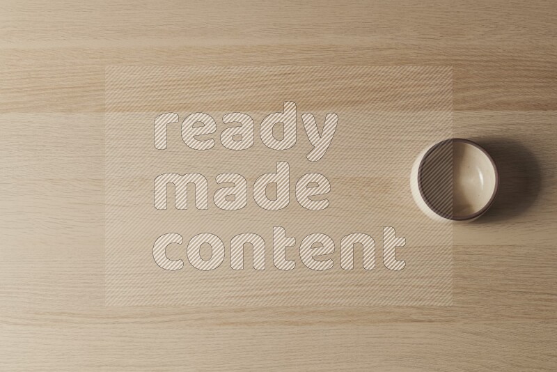 A beige pottery oven bowl on light wooden background