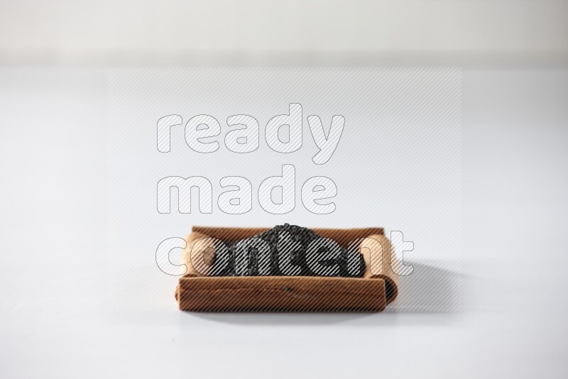 A single square of cinnamon sticks full of black seeds on white flooring
