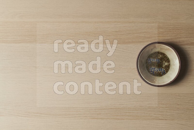 A decorative pottery plate on light wooden background