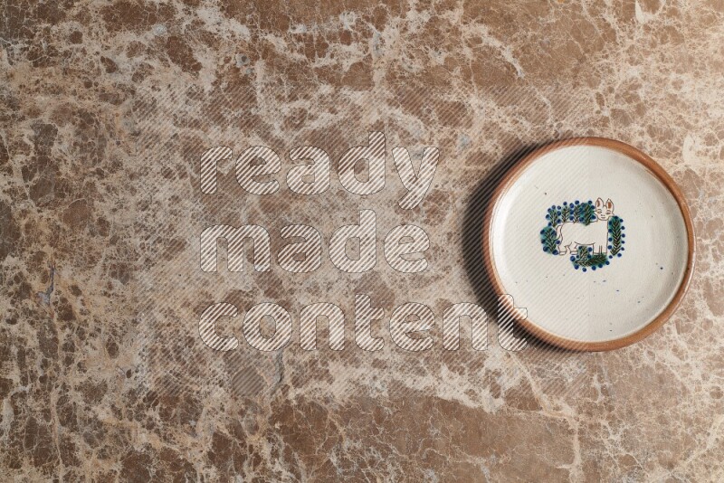 A decorative pottery plate on beige marble background