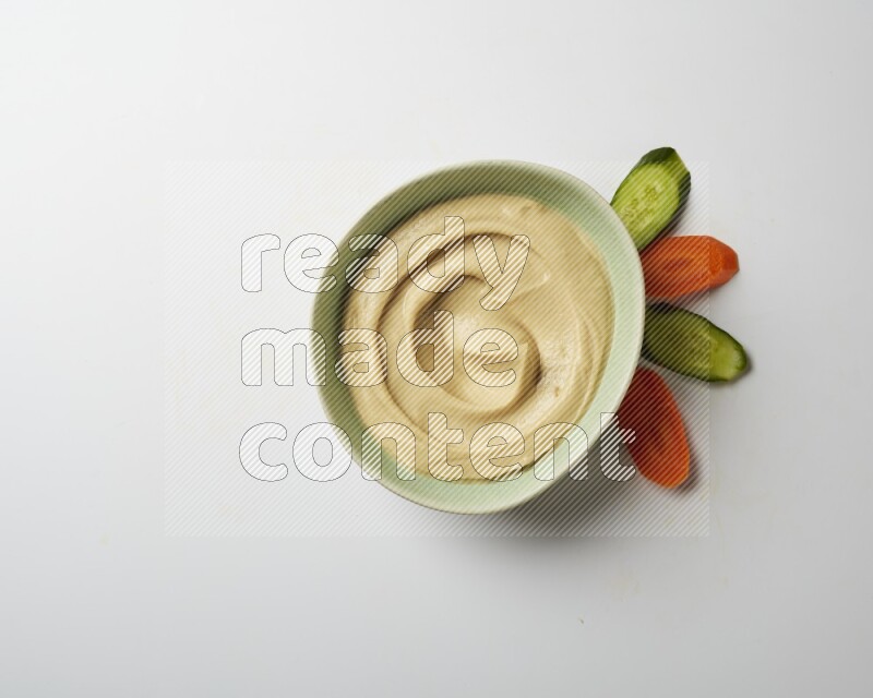plain Hummus in a green plate on a white background