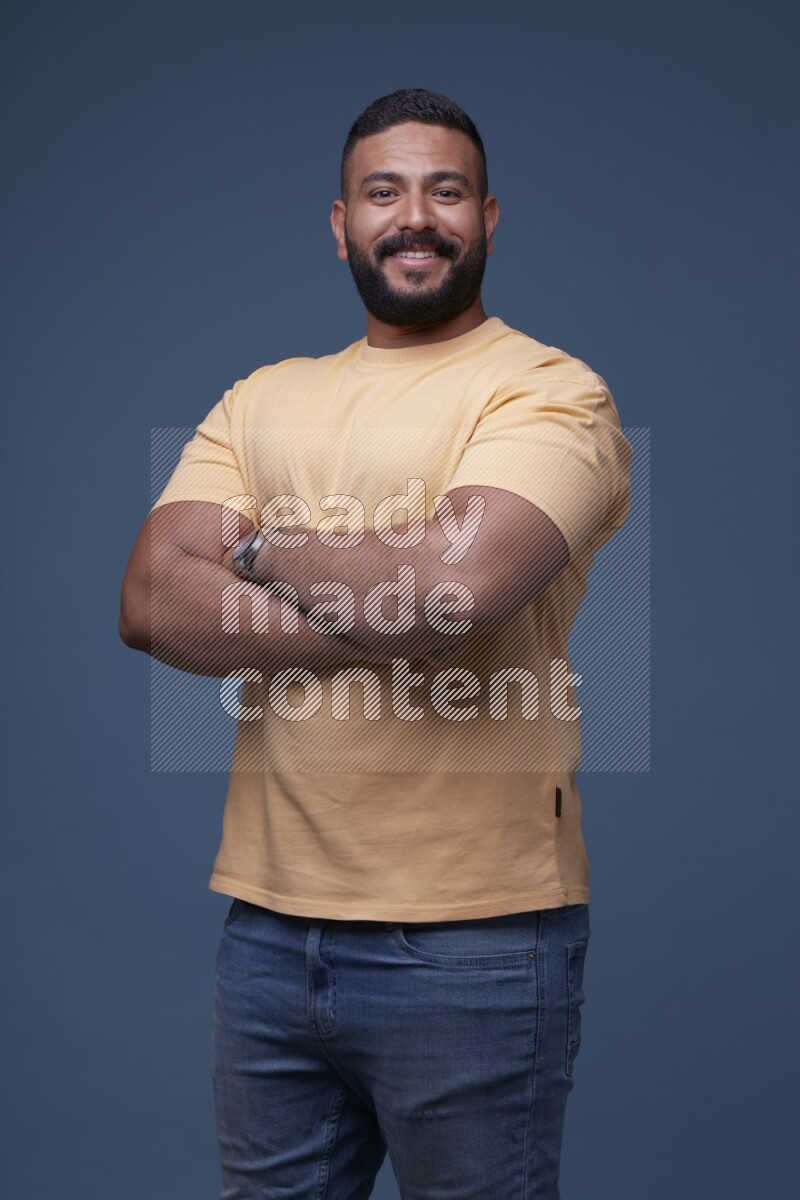 رجل يرتدي قميص اصفر بأكمام قصيرة وبنطال جينز ازرق يقف بأوضاع مختلفة