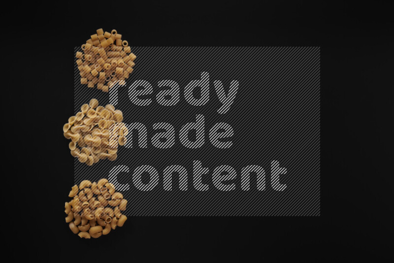 Different pasta types in 3 bunches on black background