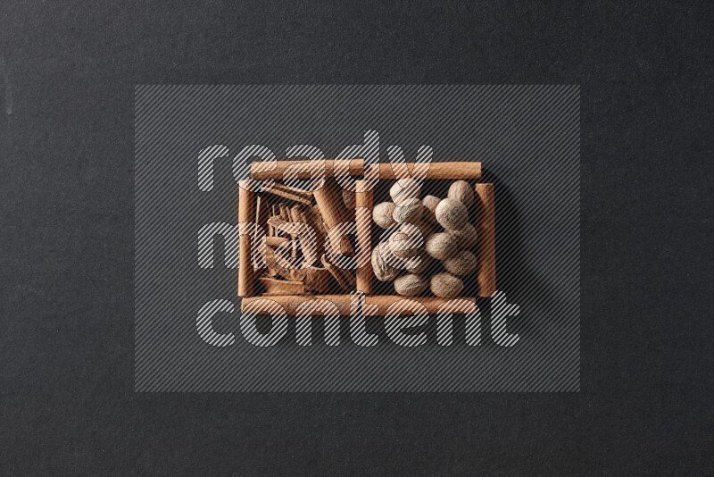 2 squares of cinnamon sticks full of cinnamon and nutmeg on black flooring
