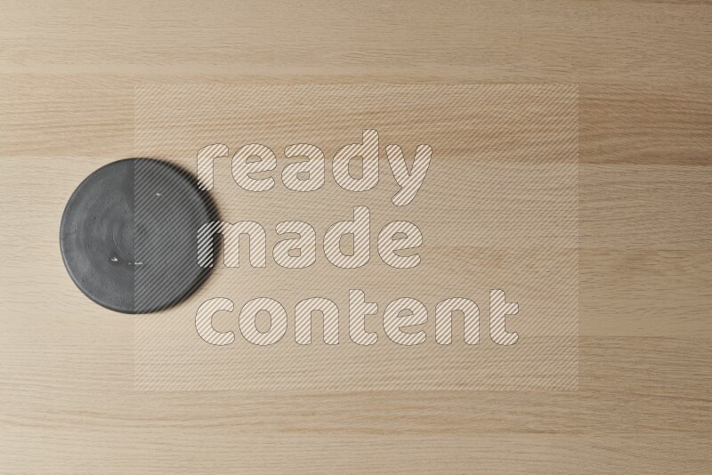 A pottery coaster on light wooden background