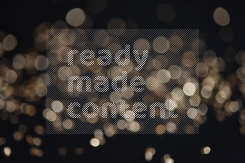 Gold shimmering fragments of glass scattered on a black background