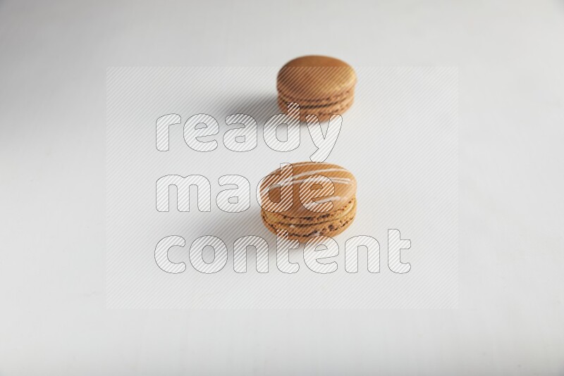 45º Shot of of two assorted Brown Irish Cream, and Brown Coffee macarons  on white background