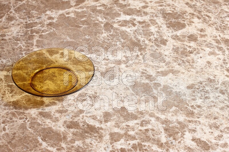 A circular glass plate on beige marble background