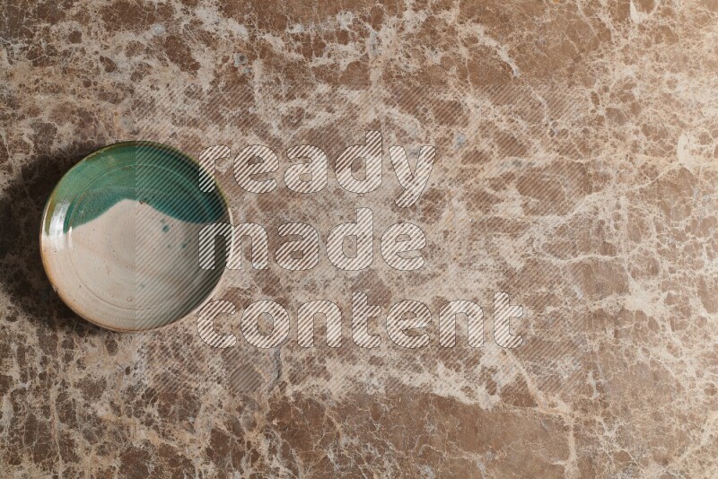 A decorative pottery plate on beige marble background