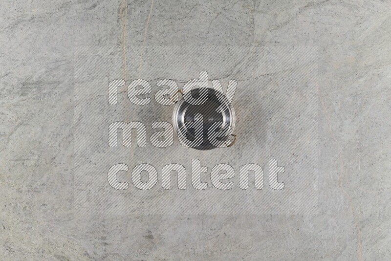 A small copper pot on grey marble background
