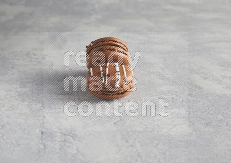 45º Shot of two Brown white marbleChocolate Caramel macarons  on white  marble background