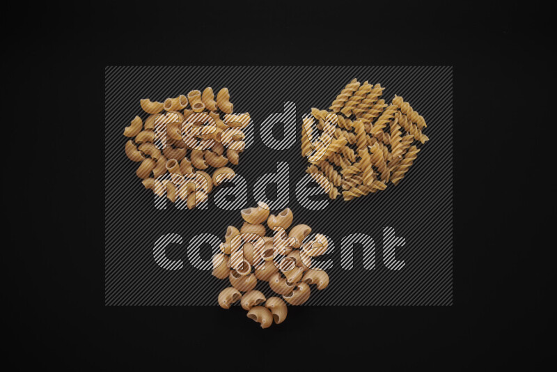 Different pasta types in bunches on black background