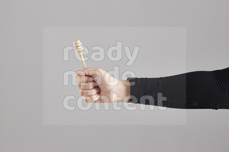 امرأة ترتدي عباءة سوداء تحمل أدوات خشبية مختلفة في أوضاع متعددة