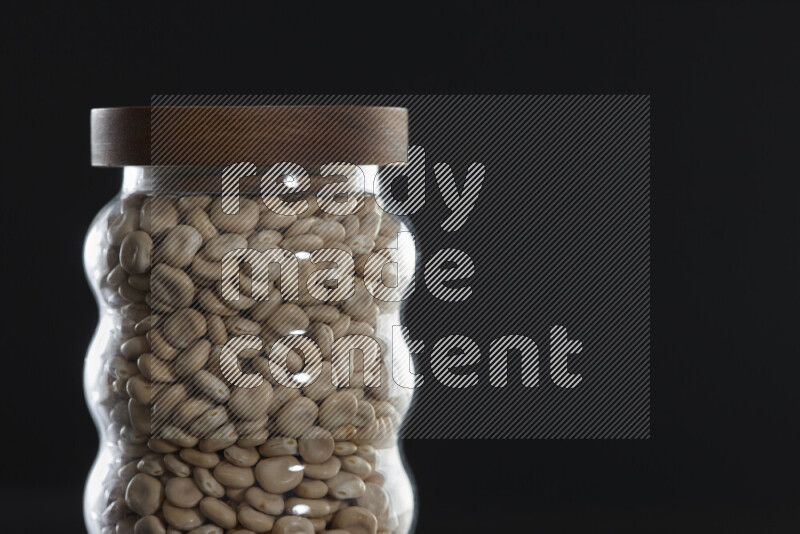 Lupin Beans in a glass jar on black background