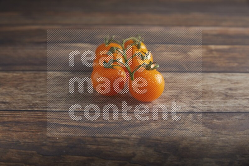 Orange cherry tomato vein on a textured wooden background 45 degree