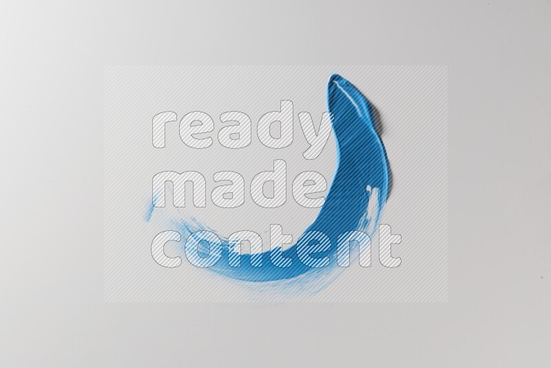 A blue single curved painting knife stroke on a white background