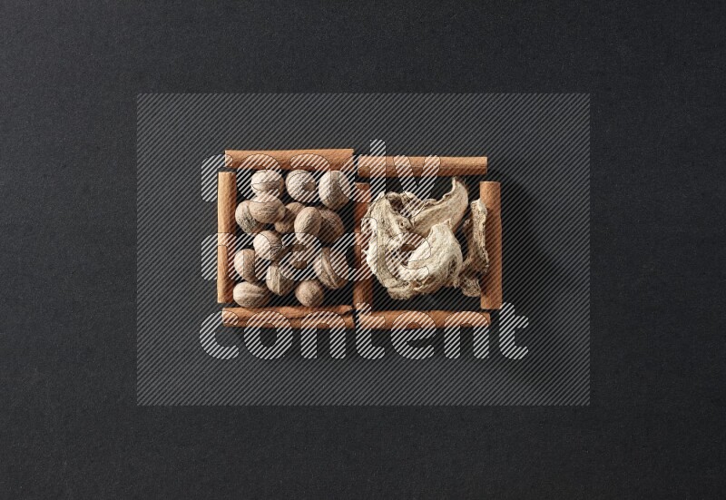 2 squares of cinnamon sticks full of nutmeg and dried ginger on black flooring