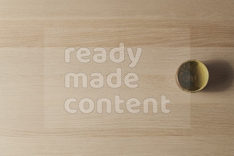 كأس فخاري متعدد الألوان على خلفية خشبية فاتحة