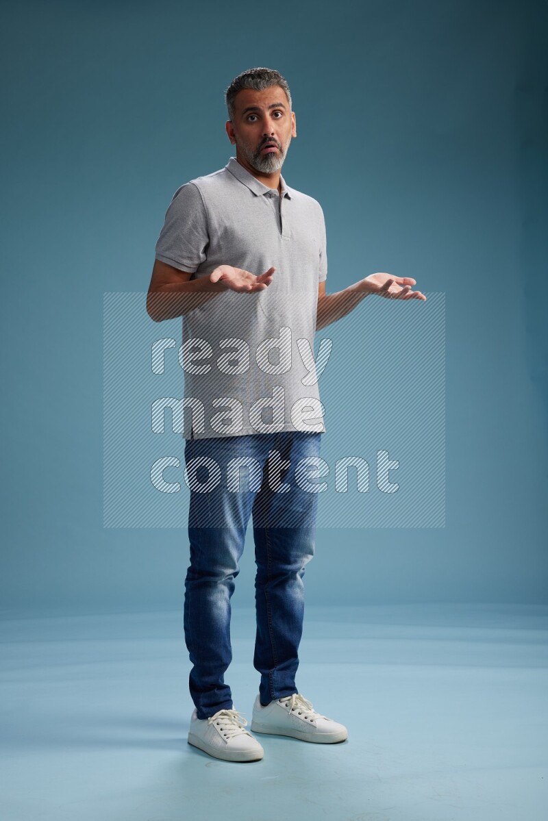 Man Standing Interacting with the camera on blue background