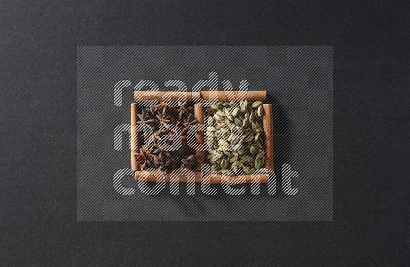 2 squares of cinnamon sticks full of cardamom and star anise on black flooring