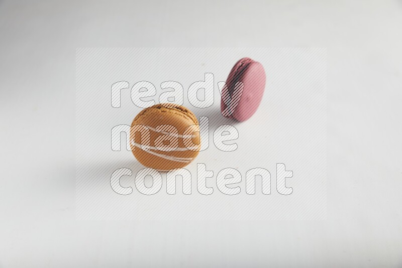 45º Shot of of two assorted Brown Irish Cream, and Red Cherry macarons on white background