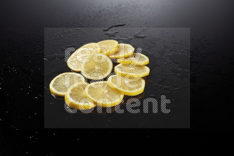 Lemon slices with water drops, and droplets on black background
