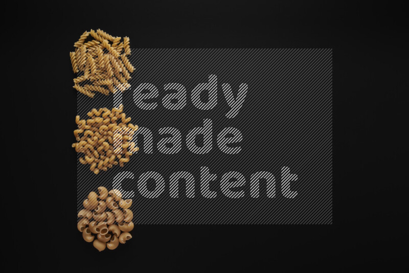 Different pasta types in 3 bunches on black background
