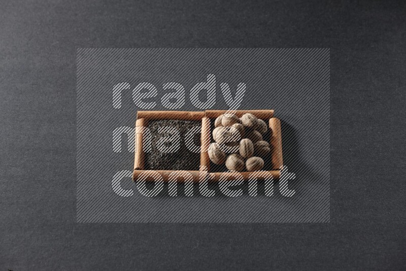 2 squares of cinnamon sticks full of tea and nutmeg on black flooring