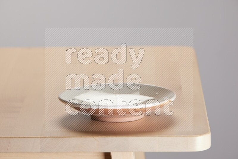 multi-colored pottery Plate on a wooden table edge