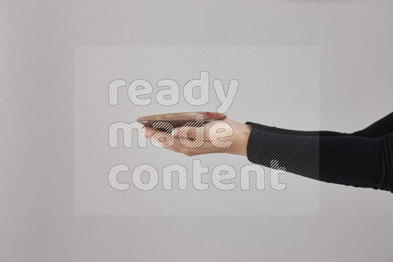 A woman in black abaya holding different pottery essentials in different positions
