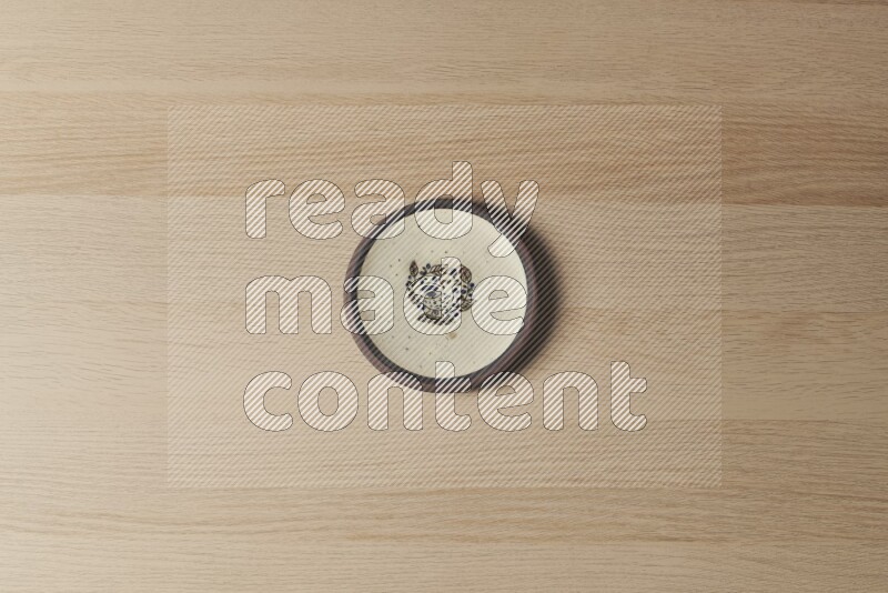 A decorative pottery plate on light wooden background