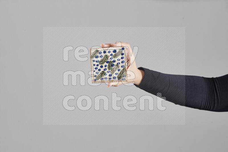 A woman in black abaya holding different pottery essentials in different positions