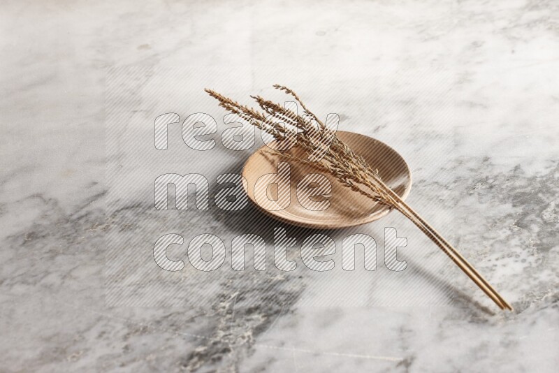 Wheat stalks on Beige Pottery Plate on grey marble flooring, 45 degree angel