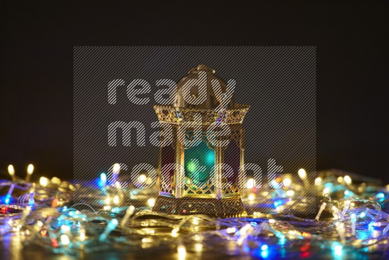 A traditional ramadan lantern surrounded by glowing fairy lights in a dark setup