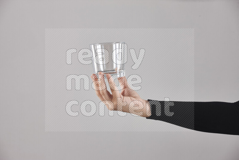 A woman in black abaya holding different glassware in different positions