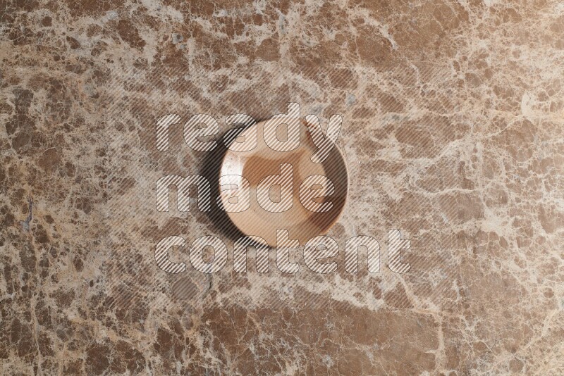 A multicolored pottery plate on beige marble background