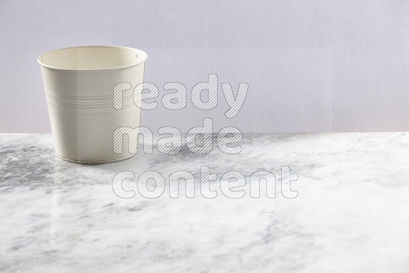 An empty white plant pot on grey marble background