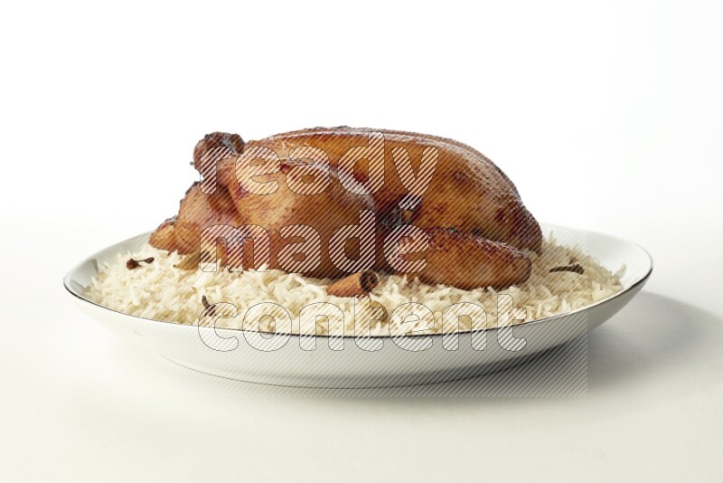 white  basmati Rice with  whole roasted chicken  on a white plate with a silver rim direct  on white background