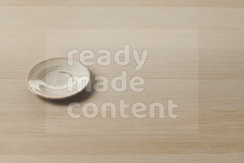 A pottery coaster on light wooden background