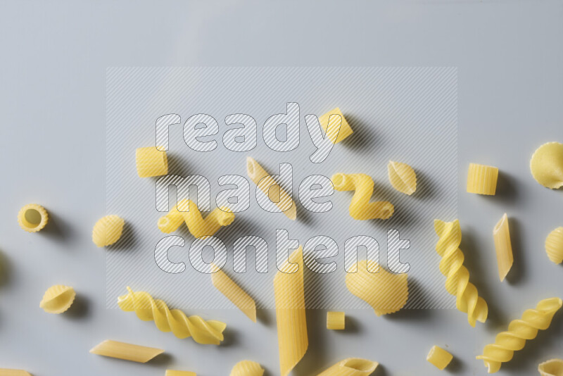 Different pasta types on light blue background