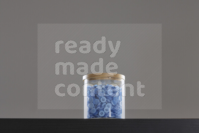 Buttons in a glass jar on black background