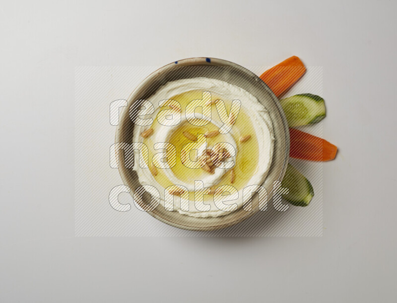 Lebnah garnished with pine nuts in a grey pottery plate on a white background