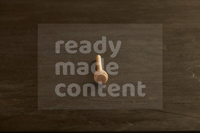 Wooden honey dipper on black slate background