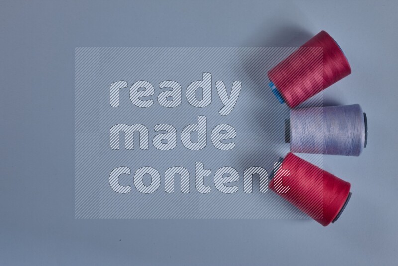 A pink collection of sewing and tailoring tools arranged on a blue background