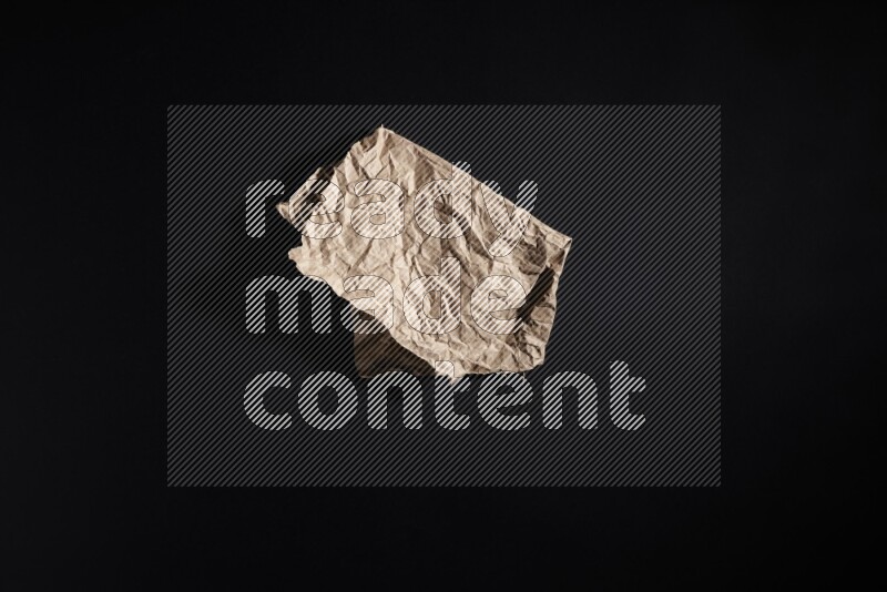 Crumpled craft paper on black background