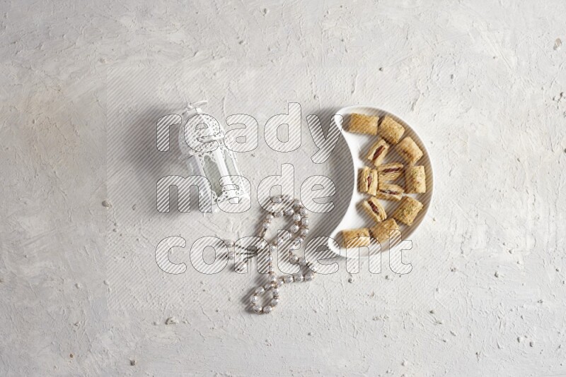 حلويات شرقية في صحن فخاري مع فانوس معدني