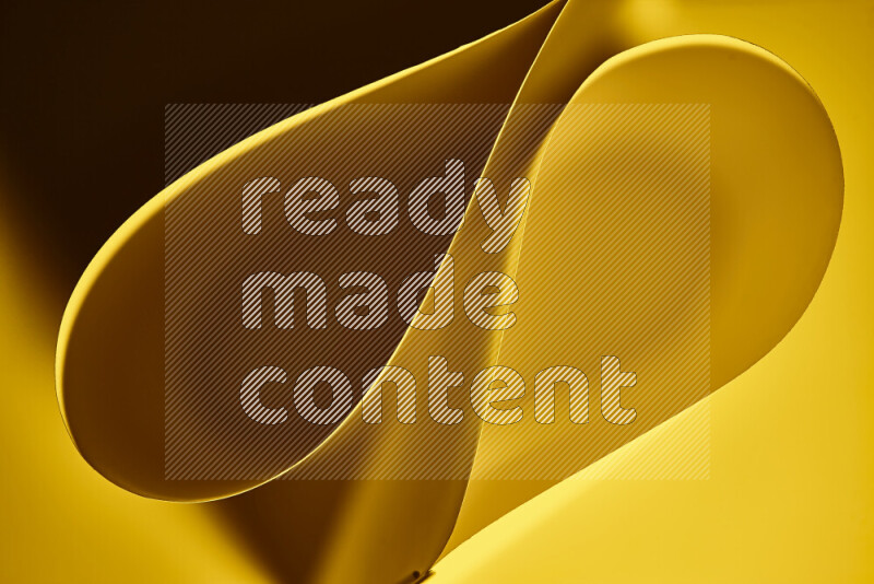 An abstract art of paper folded into smooth curves in yellow gradients