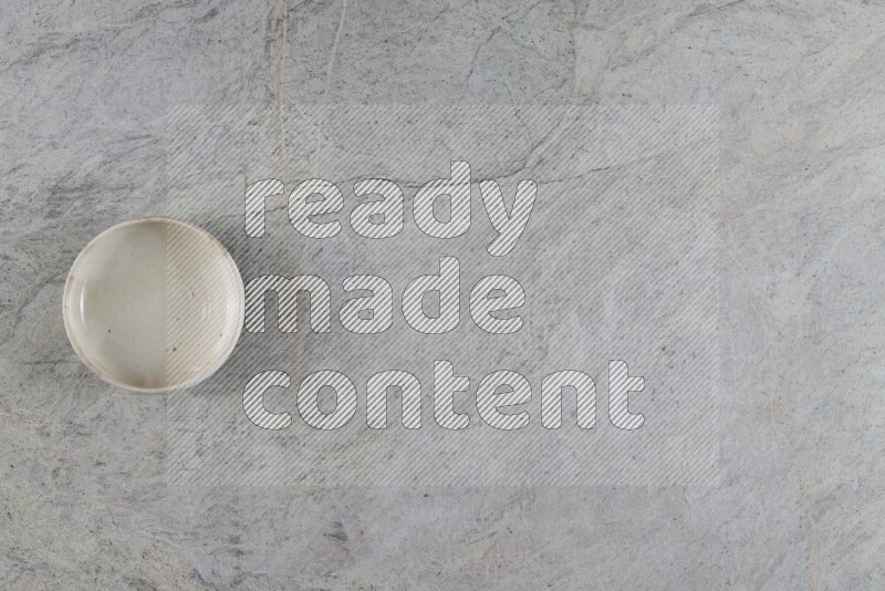 A white pottery bowl on grey marble background