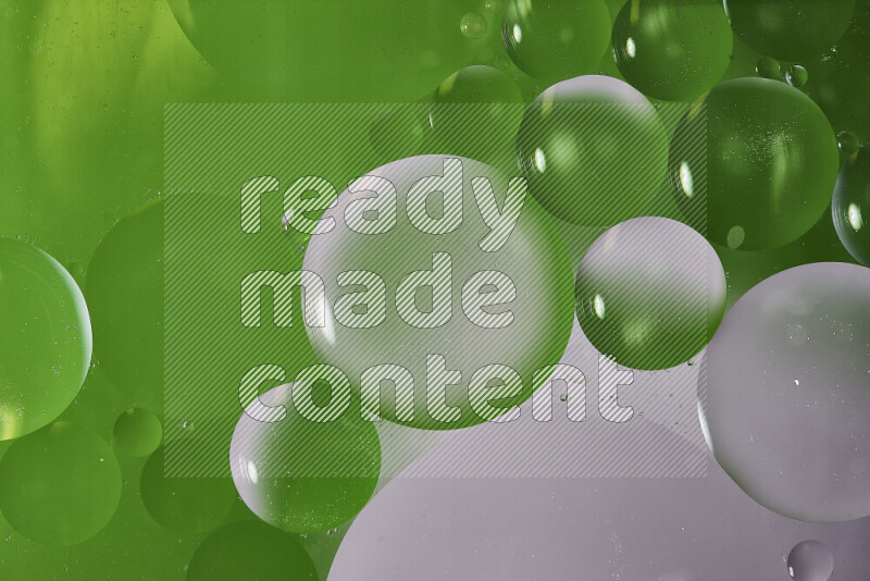 Close-ups of abstract oil bubbles on water surface in shades of white and green