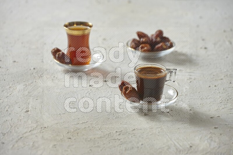 A coffee glass cup with dates and tea on textured white background